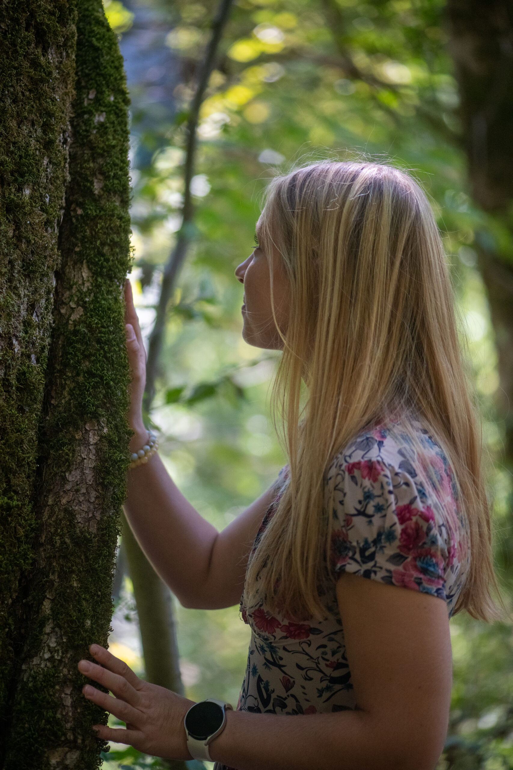 woman standing on rock facing forest
